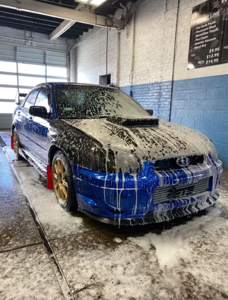 Subaru WRX STI covered in foam in the blue-brick wash bay